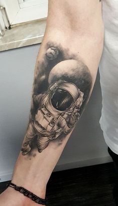 an astronaut tattoo on the arm