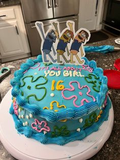 a birthday cake decorated with cartoon characters on top of a kitchen counter next to an oven