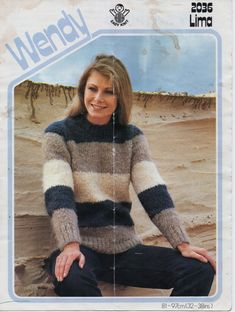 a woman sitting on top of a rock wearing a sweater