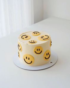 a white cake with yellow smiley faces on it