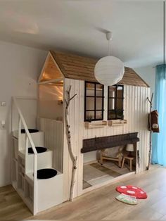 a child's room with a tree house on the wall and stairs to the second floor