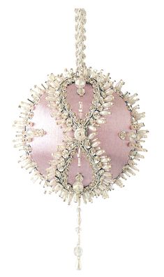 a pink ornament hanging from a chain with beads and pearls on the end