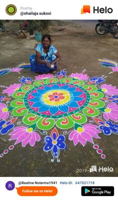 a woman is sitting on the ground next to a colorful rangdil with flowers