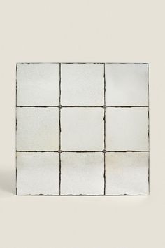 a square white tile with black lines on it