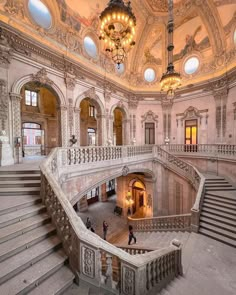 an ornate building with stairs and chandeliers