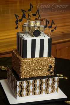 a three tiered cake with musical notes on it and a drum in the middle