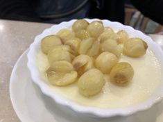 a white bowl filled with food on top of a table