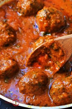 meatballs and tomato sauce in a pan with a wooden spoon on the side, ready to be eaten