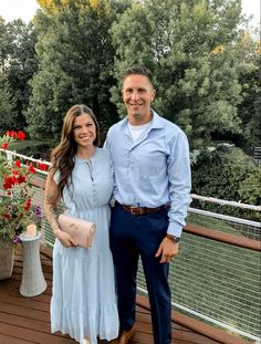 a man standing next to a woman on top of a wooden deck