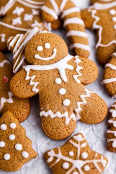 gingerbread cookies with white icing and decorations on top are arranged in a pile