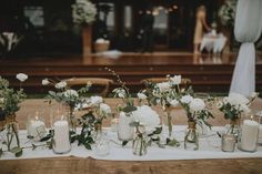 the table is set with candles, flowers and greenery for an elegant wedding reception