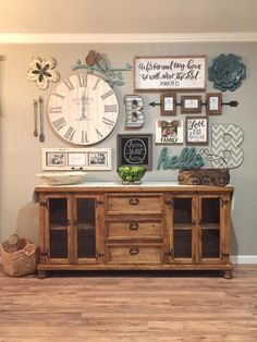 a living room with a large clock and pictures on the wall next to a wooden cabinet