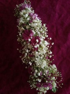 a bouquet of flowers sitting on top of a purple cloth