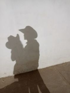 a shadow of a person with a hat on