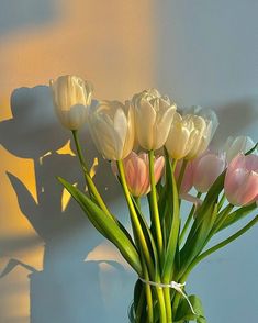 a vase filled with pink and white tulips