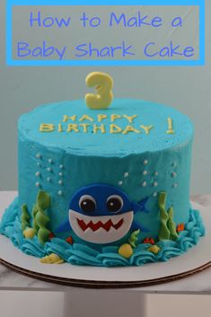 a blue birthday cake with a shark on top and the number 3 in the middle