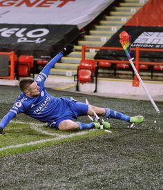 a soccer player laying on the ground with his arms in the air and legs out