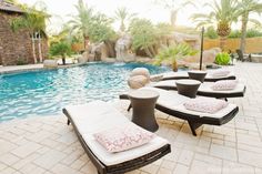 lounge chairs are lined up next to the pool