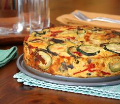 a cake sitting on top of a metal pan covered in cheese and veggies