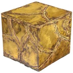 a gold colored cube shaped object on a white background with an interesting design in the center