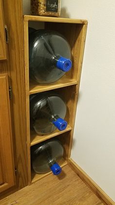 a wooden shelf with several plastic bottles in it