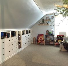 a room with many drawers and shelves on the wall next to a cat sitting in a chair