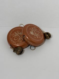 two brown frisbees sitting on top of each other with bells attached to them