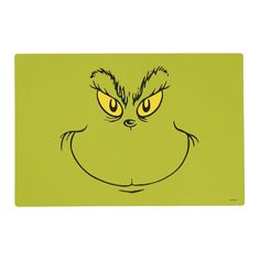 the grin face is drawn on a green placemat with yellow eyes and an angry grin