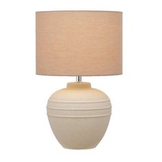 a white ceramic table lamp with a beige shade