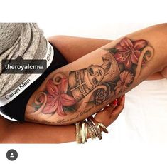 a woman's arm with tattoos on it and flowers in the middle of her leg