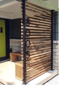 a wooden slatted door on the side of a house with a bench in front