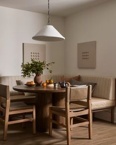 a dining room table with two chairs and a potted plant on top of it