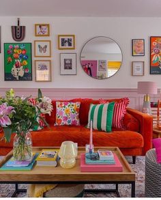 a living room filled with lots of furniture and pictures on the wall above it's coffee table