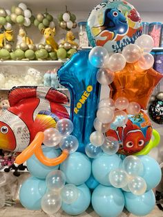 some balloons and other items on a table in a room filled with decorations, including an orange fish balloon