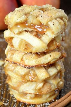 a stack of apple pies sitting on top of a wooden table