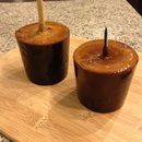 two brown cups sitting on top of a wooden cutting board