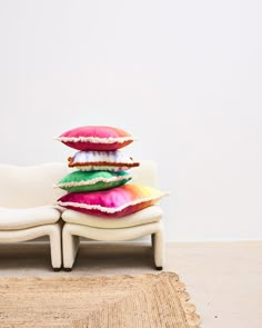 a stack of pillows sitting on top of a white couch