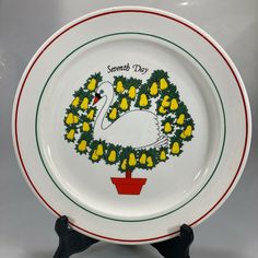 a white plate with yellow flowers and a wreath on the front is sitting on a table