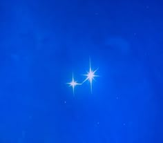 two bright white stars against a blue sky