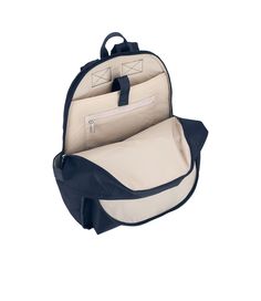 Features two zip closure compartments with dual zipper pulls, 1in/2.5cm top loop handle (Drop: 2.2in/5.5cm), Adjustable padded shoulder straps (Min Length: 18.5in/47cm, Max Length: 36.5/92.7cm), Exterior front zip closure pocket, Exterior back panel features a zip closure cell phone pocket on the side, Two exterior side open top pockets, Interior of front compartment features two open pockets on the interior back wall, Interior of back compartment features a laptop pocket with Velcro tab closure Blue Backpack With Zipper For Commuting, Navy Backpack With Zipper For Everyday Use, Blue Backpack With Zipper Closure For Commuting, Navy Backpack With Zipper Closure, Navy Backpack With Zipper Closure For Everyday Use, Blue Backpack With Adjustable Strap For Commuting, Navy Backpack With Adjustable Strap For Everyday Use, Wall Interior, Blue Solid