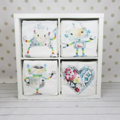 four square dishes with cartoon characters on them in a white box against a polka dot wall