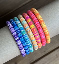 colorful bracelets are lined up on a bench