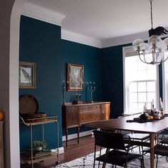 a dining room with blue walls and white trim