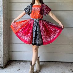 a woman standing in front of a garage door wearing a dress with an orange and black design