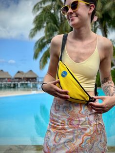 a woman holding a banana in front of a pool