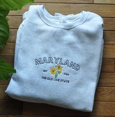 This item is made to order. Please allow 1 week for processing before the item is shipped. State of Blossoms crafts machine embroidered sweatshirts in Bel Air, MD. Please send me a message for custom orders. I'd love to work with you to design something you love. **SIZES ARE UNISEX** Made from a perfectly balanced blend of 50% cotton and 50% polyester fibers, Nublend Jerzees Crewneck Sweatshirts are both comfortable and stylish. This adult, unisex style is light-to-mid weight at 8 oz. Sample col Crew Cotton Sweatshirt With Machine Embroidery, Cotton Crew Sweatshirt With Machine Embroidery, Embroidered Cotton Sweatshirt For College, Crew Neck Cotton Sweatshirt With Machine Embroidery, Cotton Crew Neck Sweatshirt With Machine Embroidery, Cotton Sweatshirt With Machine Embroidery For College, Embroidery Crewneck, Flower Black, Black Eyed Susan