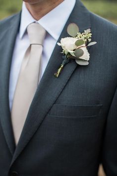 a man in a suit and tie with a boutonniere on his lapel