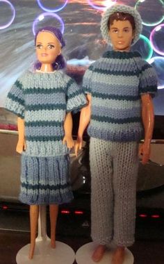 two dolls standing next to each other in front of a tv