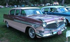 several old cars are parked on the grass