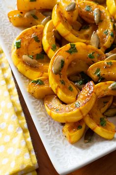 roasted delicata squash with maple brown butter sauce is shown on a white plate